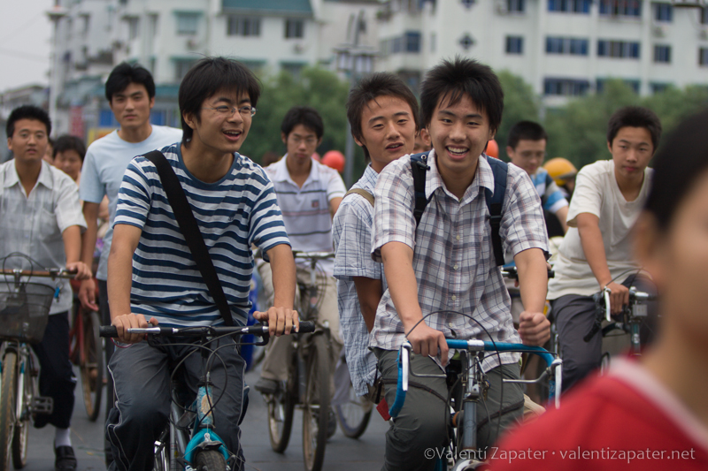 Jóvenes sonrientes desplazándose en bicicleta por la ciudad china de Tunxi (Huang Shan Shi)